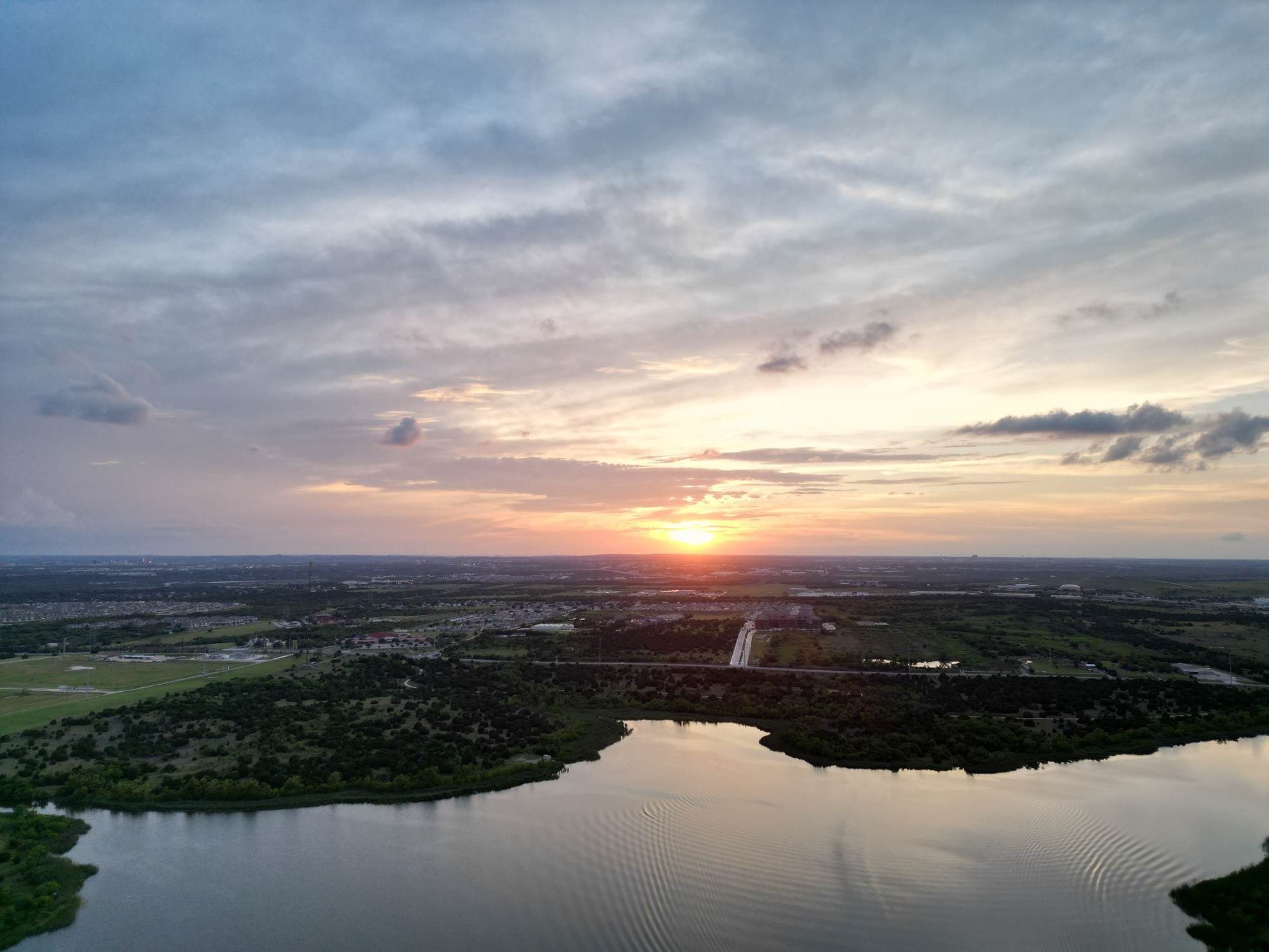 Sunset view over Walter E. Long Lake near Ryder Ridge in East Austin, showcasing open water and scenic Texas skies