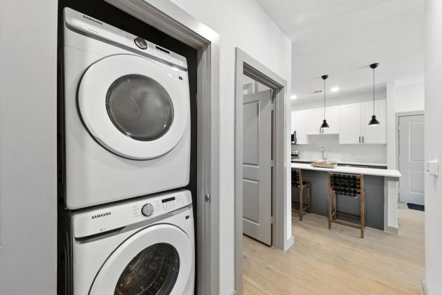 In-home laundry at Ryder Ridge featuring a stacked washer and dryer conveniently located near the kitchen area.