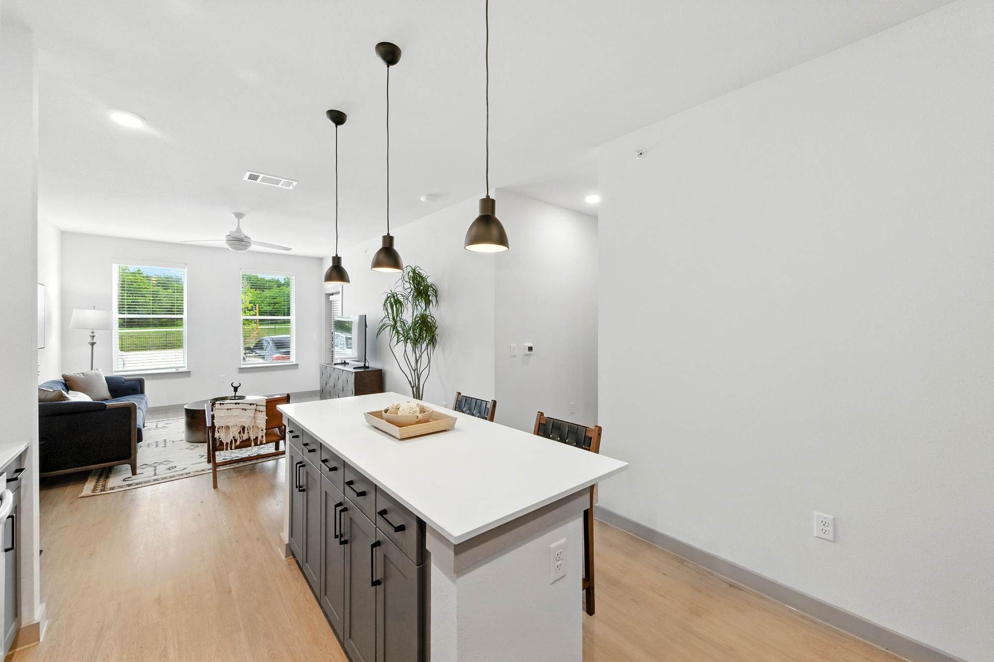 Open-concept kitchen at Ryder Ridge featuring a large island with pendant lighting and bright natural light from nearby windows.