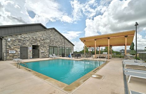 Resort-style swimming pool at Ryder Ridge with poolside seating and a shaded lounge area under a bright Texas sky.
