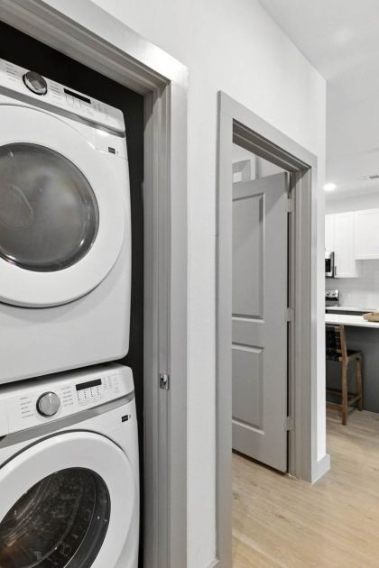 In-home laundry at Ryder Ridge featuring a stacked washer and dryer conveniently located near the kitchen area.