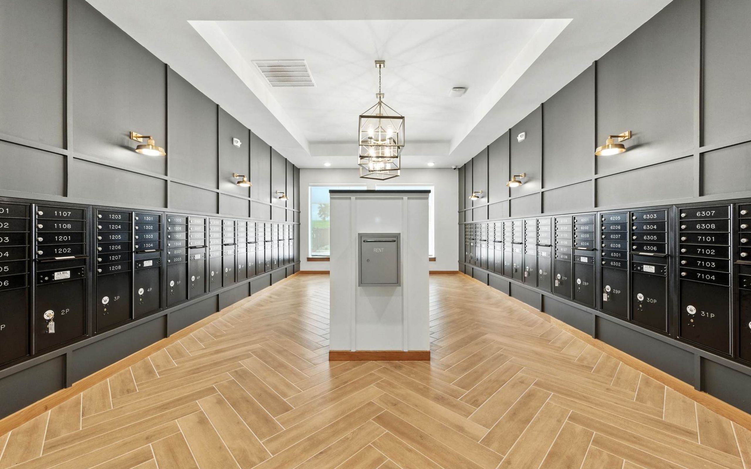 Spacious package room at Ryder Ridge featuring modern black lockers, wood-style flooring, and elegant lighting