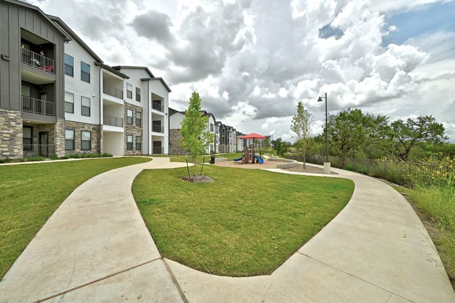 Spacious courtyard at Ryder Ridge with walking paths, green lawns, and views of the apartment buildings.