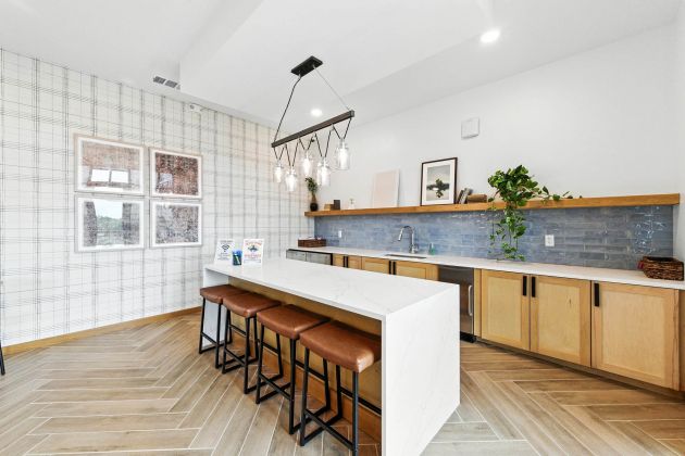 Resident lounge at Ryder Ridge featuring a modern bar-style counter, leather seating, and contemporary lighting with warm, inviting design.