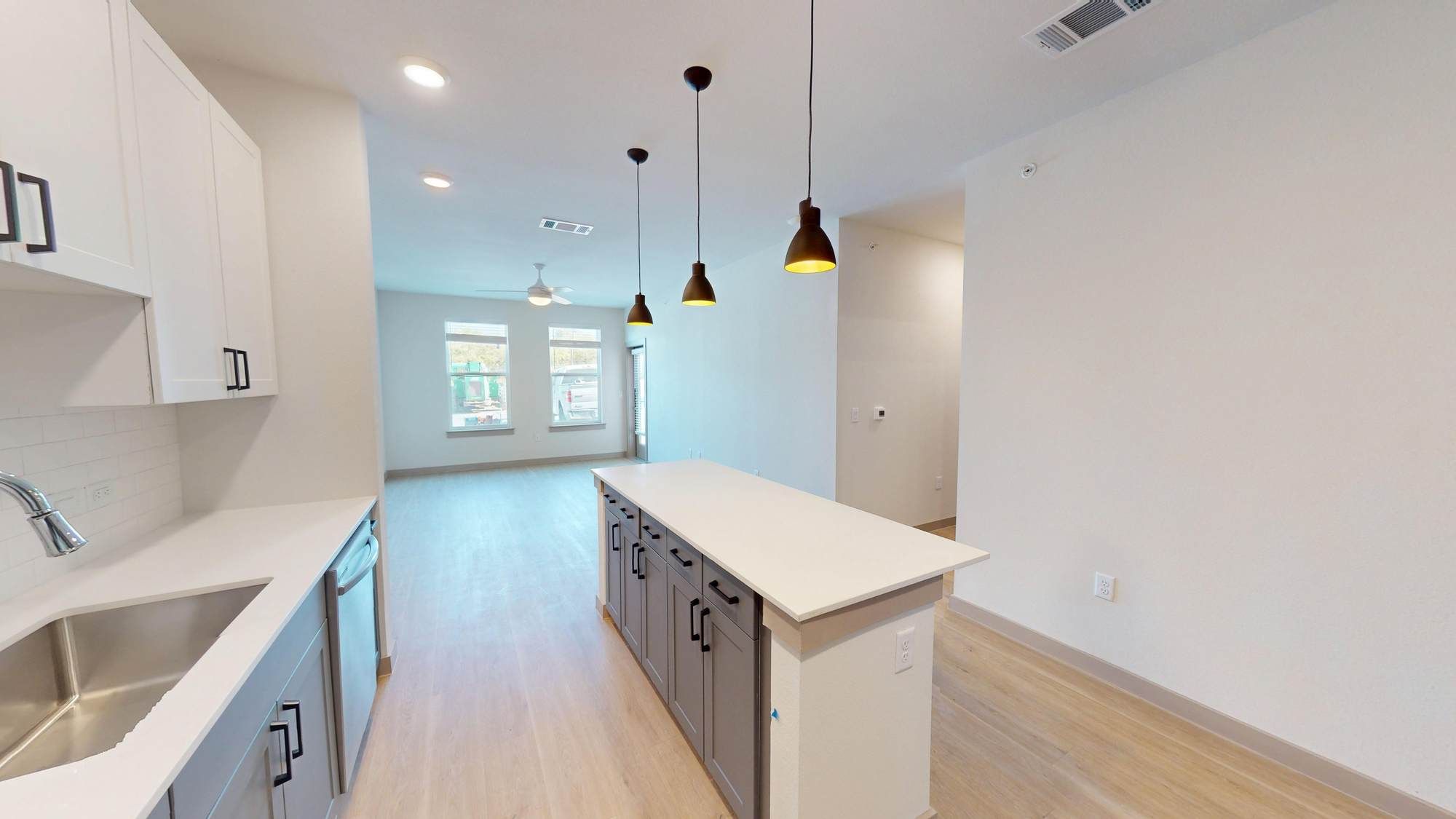 Open-concept living area at Ryder Ridge with a large kitchen island, bright windows, and modern finishes.