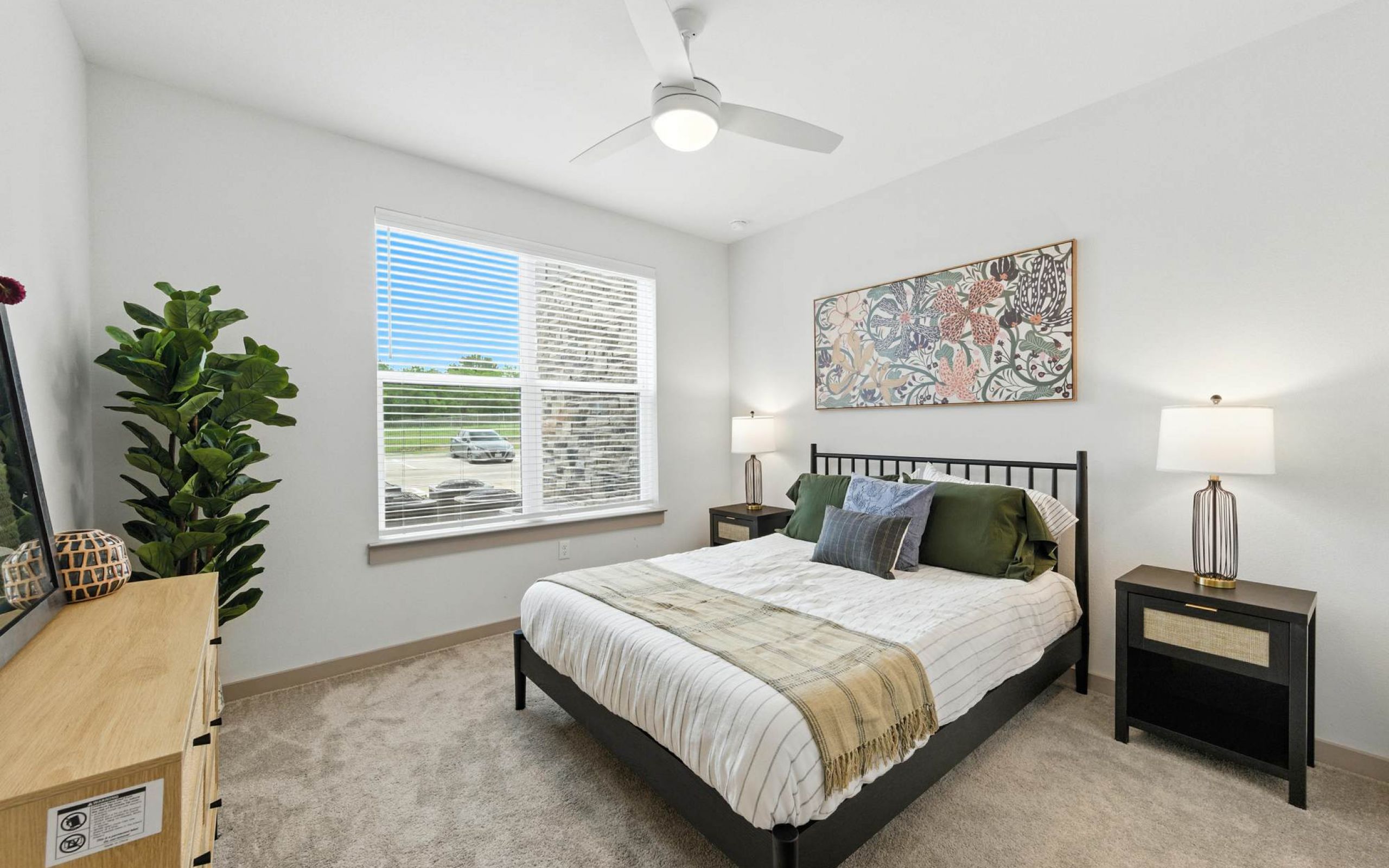 Bright bedroom at Ryder Ridge featuring plush carpeting, large window light, and modern neutral decor.
