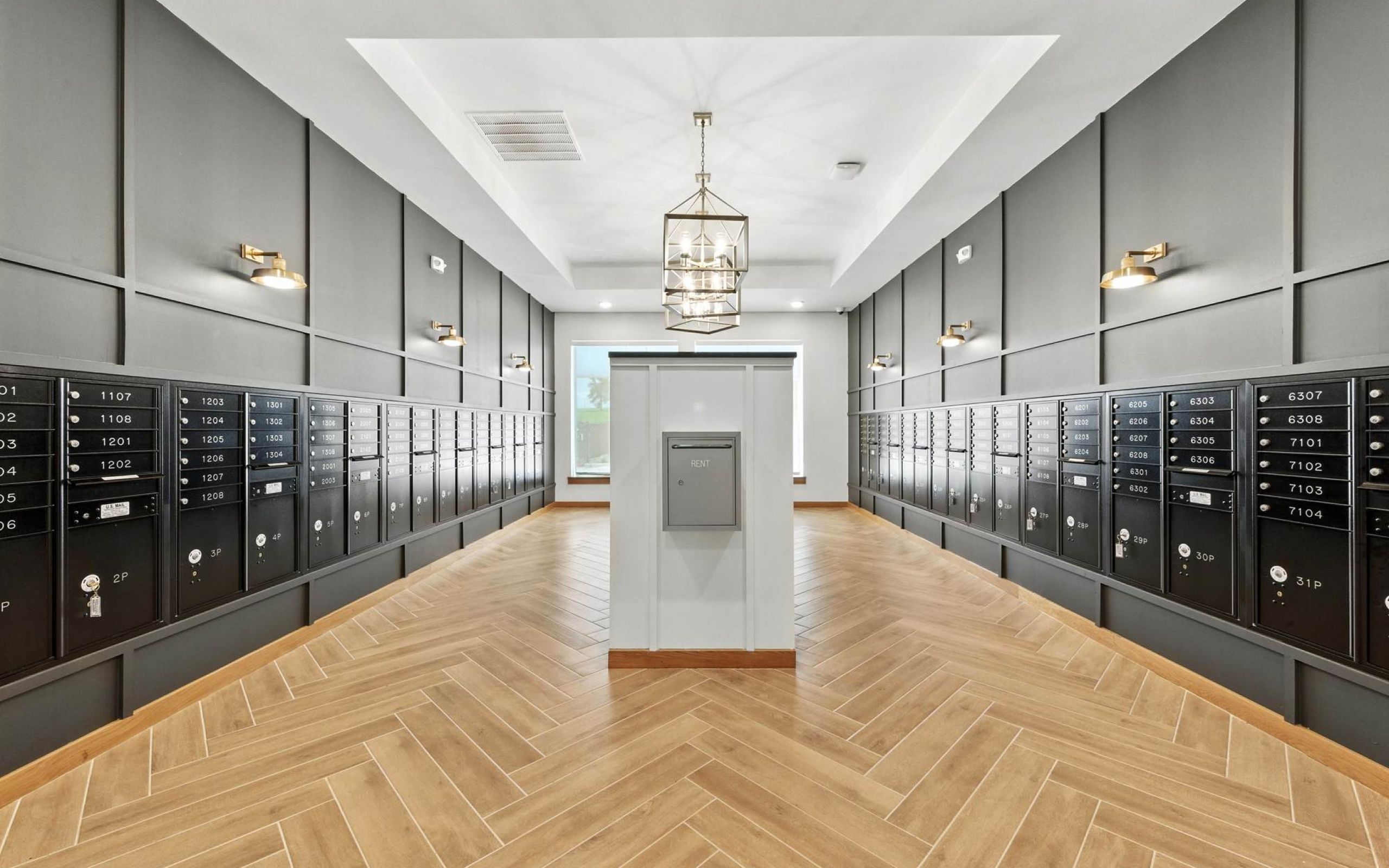 Spacious package room at Ryder Ridge featuring modern black lockers, wood-style flooring, and elegant lighting